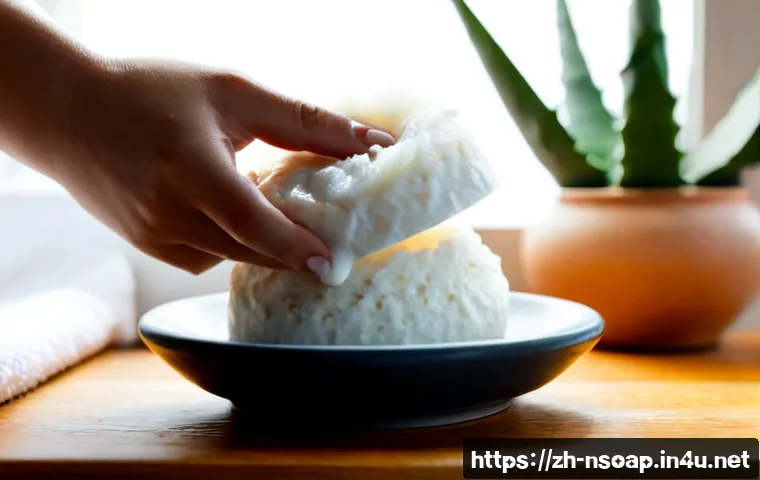 천연비누 피부 보습 - Photorealistic close-up of a creamy natural soap bar beside a small ceramic dish, fresh aloe leaves,...